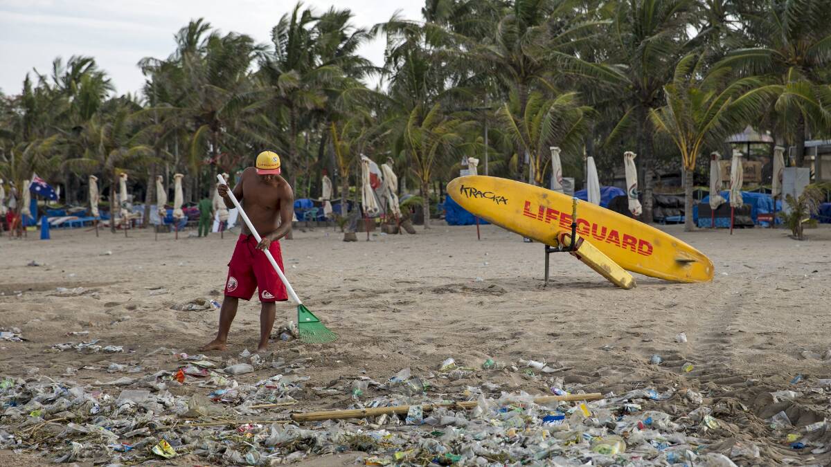 Lifeguards clean a Balinese beach in January 2014. Pic: Jason Childs