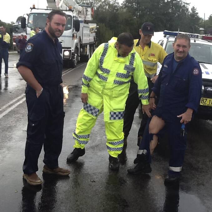 RIPPED UP: Senior Constable Brad Smith and a police rescue officer, examine paramedic Bill Rathbones pant leg after the rescue in 2015.