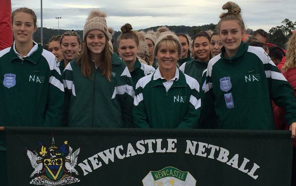 COUNTRY CHAMPS: Erin Asquith, Kim Williams, Narelle Eather and Keeley Mullins hold up the Newcastle Netball Association banner in Gosford for the State Championships. Picture: Facebook