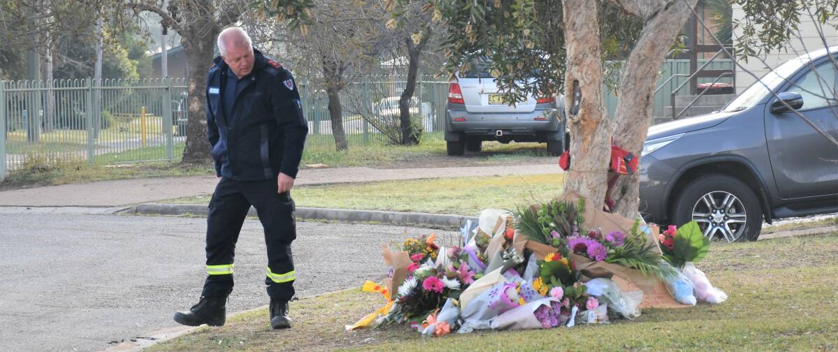 IN MEMORY: Captain Bruce Ambrose lays some flowers before his Singleton 444 Fire & Rescue team only two days after the tragic Brittliffe Close house fire which took the lives of 11-year-old Blake Atkins and his five-year-old twin sisters Matylda and Scarlett.
