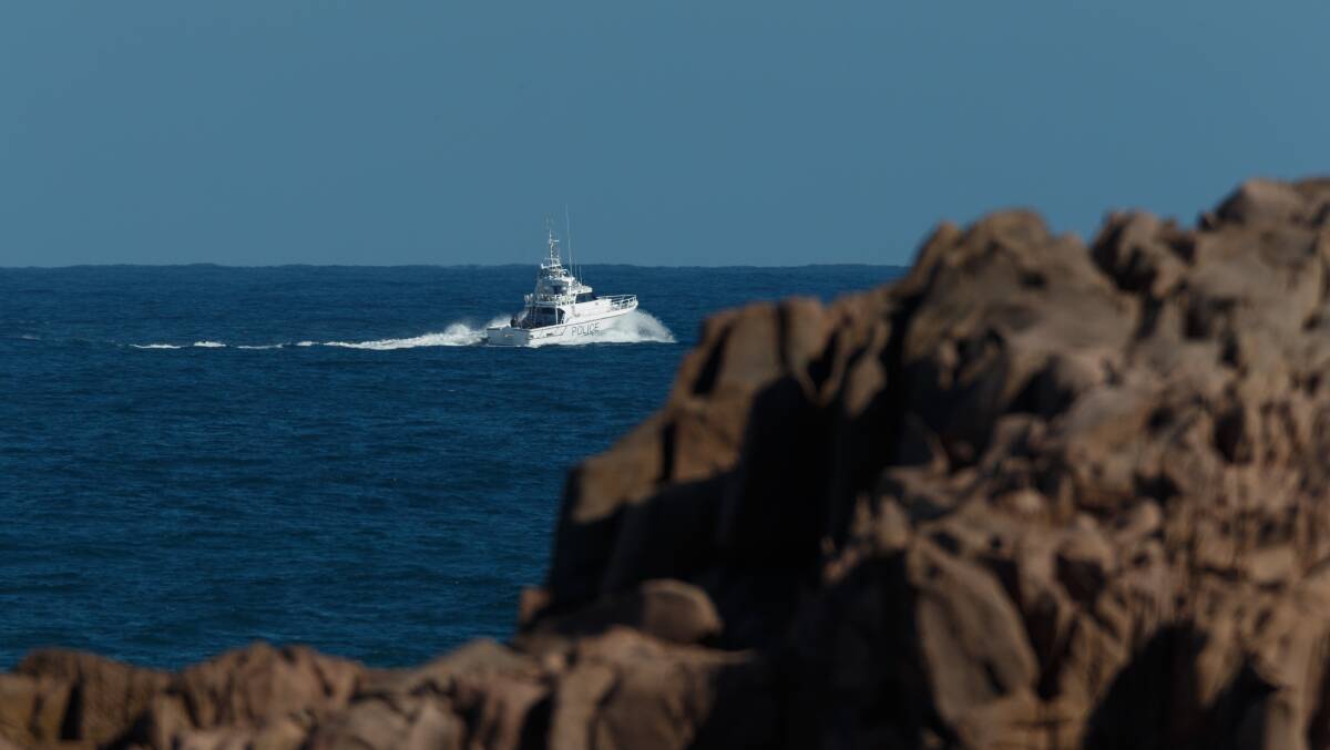 Calmer seas: A Police Marine Command boat heads out to survey the crash site on Wednesday. Picture: Max Mason-Hubers
