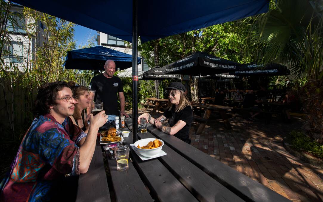 Open-air: Wickham Park Hotel co-owner Marcus Wright (standing) with outdoor diners at the pub on Thursday. Picture: Marina Neil