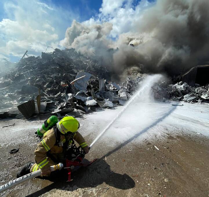 Battling: A firefighter at the scene of the scrap heap blaze on Sunday. Picture: Fire and Rescue NSW