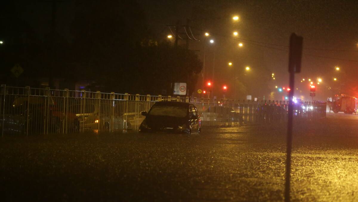 Deluge: A car caught in a flash flood at Broadmeadow. Picture: Jonathan Carroll