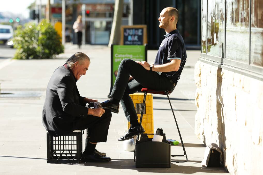 At work: Donny Rumney gives the shoes of Ryan Wall a once-over outside Newcastle Courthouse on Tuesday. Picture: Jonathan Carroll