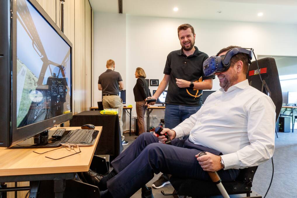 In control: Gavin Ryde of Bohemia Interactive helping Portugal's ambassador Pedro Rodrigues da Silva try out a military-grade virtual reality helicopter simulator. Picture: Max Mason-Hubers