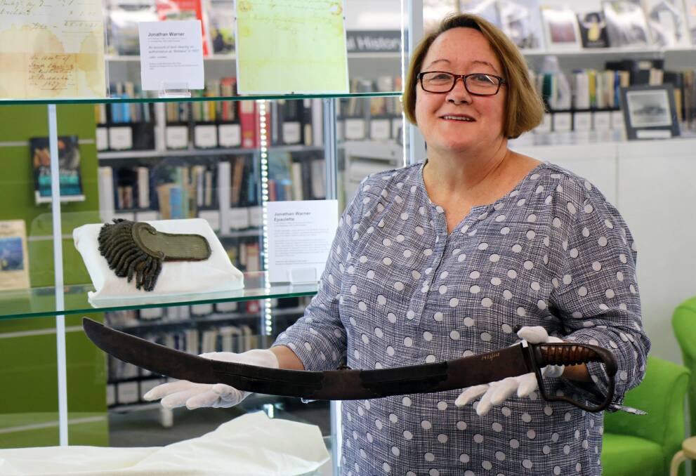 Historic item: Lake Macquarie City Council Community Historian Ann Crump with the sabre once owned by Jonathan Warner, after whom Warners Bay was named.