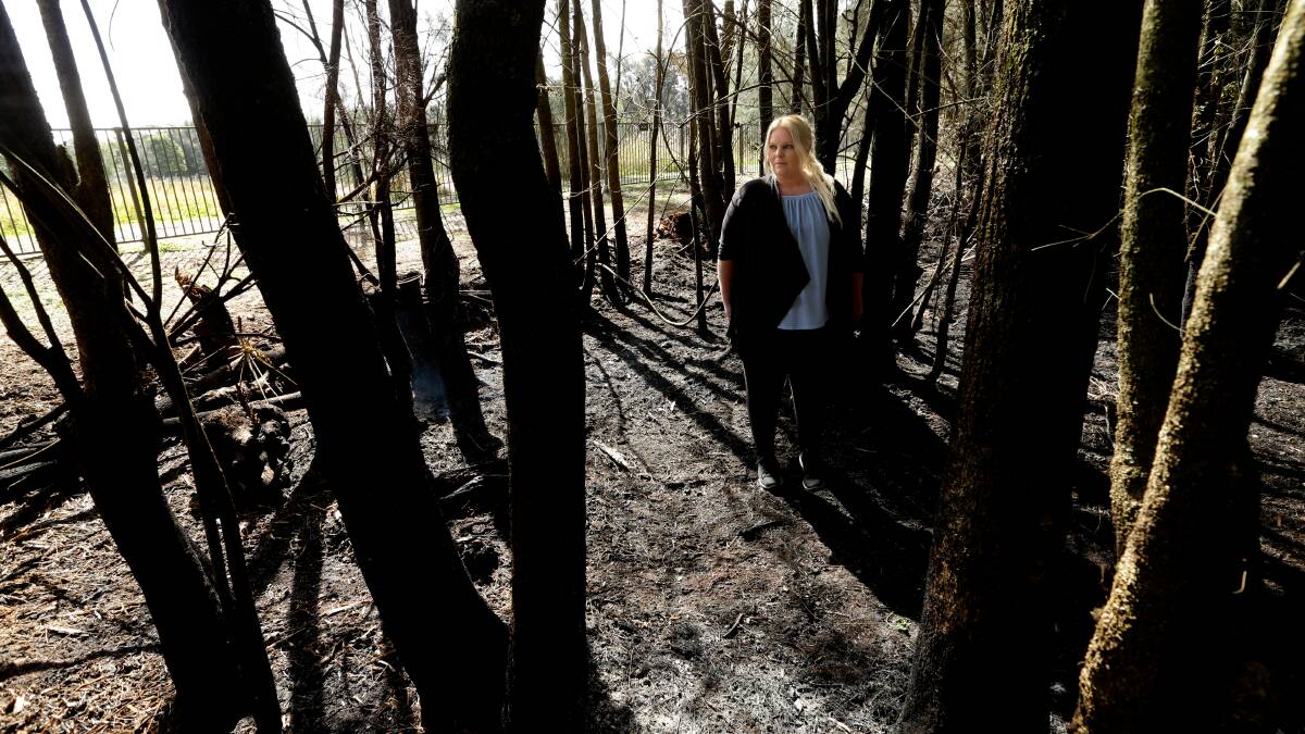 Charred: John Darling Avenue resident Jane McNamee in the burnt bushland near her home on Friday. Picture: Jonathan Carroll