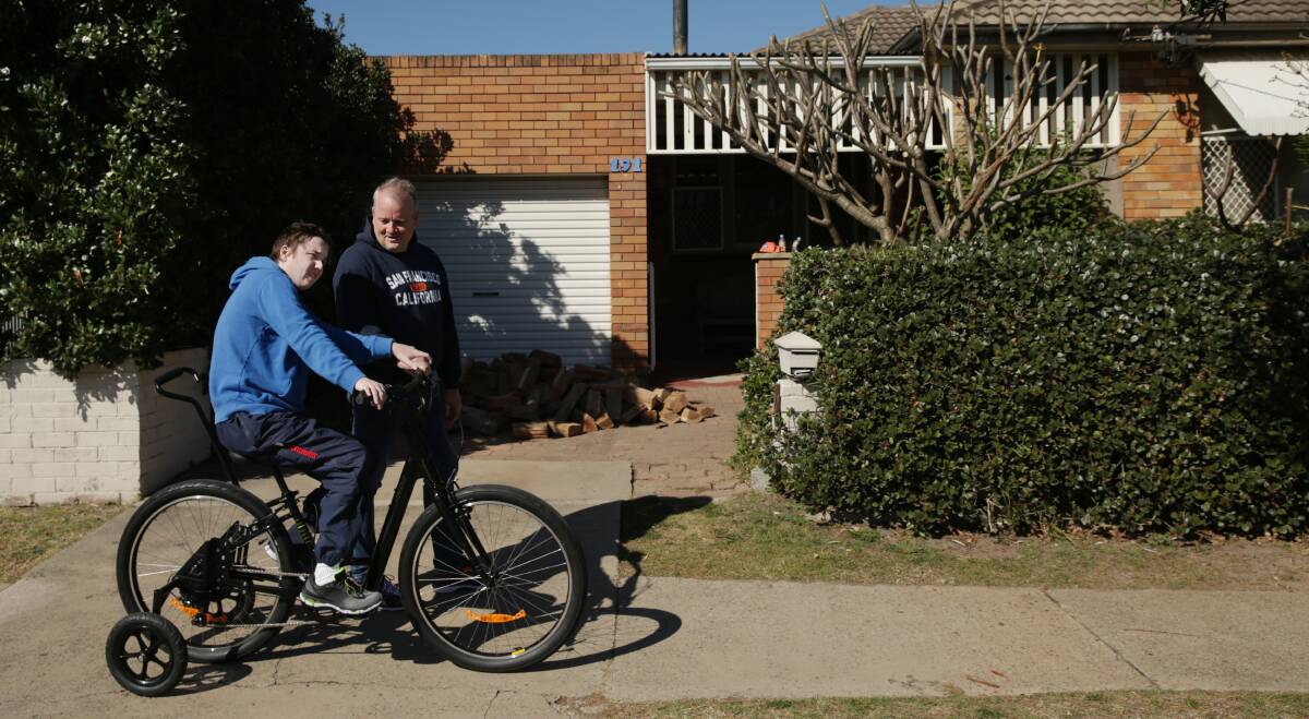 Sam Marks, with his dad Adam, taking the specially-made bike for a spin after it was returned. Picture: Simone De Peak