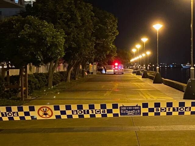 GRIM: Police on scene along Newcastle harbour on Saturday night after a man's body was found by two fishermen. Police are looking for anyone with information.