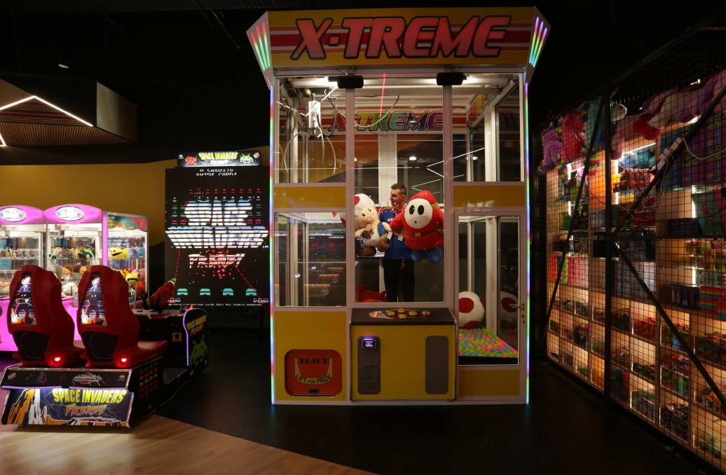 RELIVING OUR YOUTH: Customer Service attendant Jamie Warner inside the X-Treme Claw Machine at Timezone Kotara. 