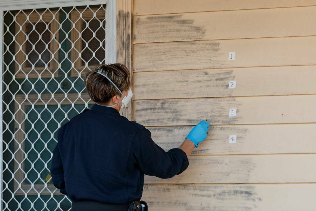 INVESTIGATION: Specialist police examining the crime scene at the front door of a home at Stockton where Stacey Klimovitch was shot and killed in June. Picture: Max Mason-Hubers
