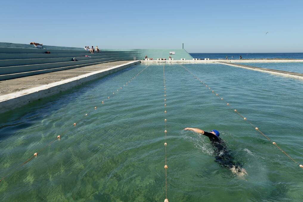 SPLASH: The conditions were pretty much as good as it gets for a winter swim in the Newcastle ocean baths on Sunday. Picture: Jonathan Carroll 