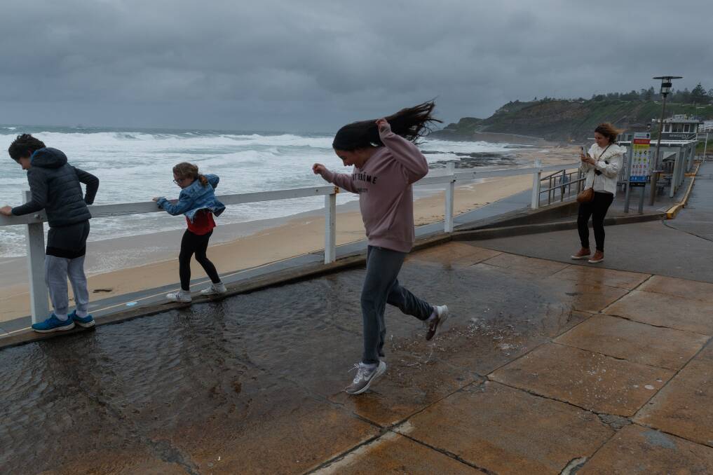 WILD WEATHER: The Risorto family of Wollongong sees the sights during a gap in the rain at Newcastle Beach on Sunday. Newcastle recorded about 15mm of rain on Sunday, but the SS warned the worst is yet to come. Picture: Max Mason-Hubers 
