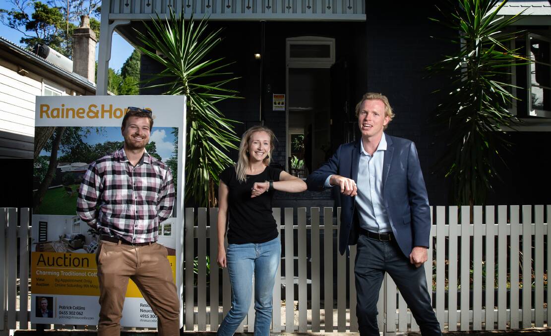 SOLD: First home buyers Sam Broadbent and Courtney Byfield with Raine and Horne's Patrick Collins on Saturday at one of Newcastle's first auctions since coronavirus restrictions were eased. Picture: Marina Neil 
