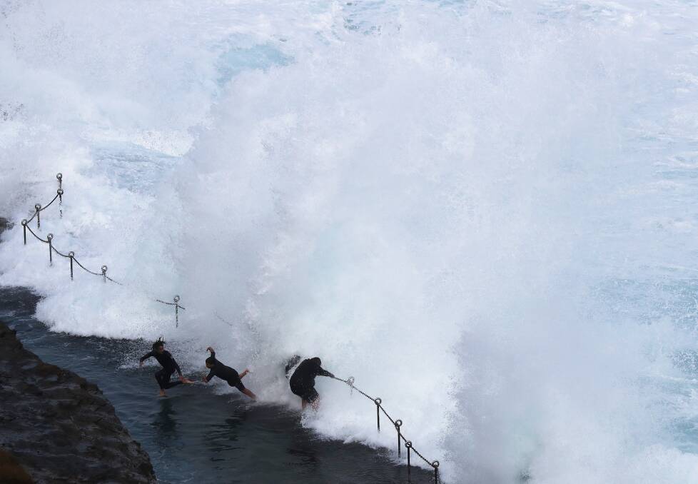WILD SURF: Swimmers take their chances in the Bogey Hole despite powerful surf on Saturday. Picture: Peter Lorimer 
