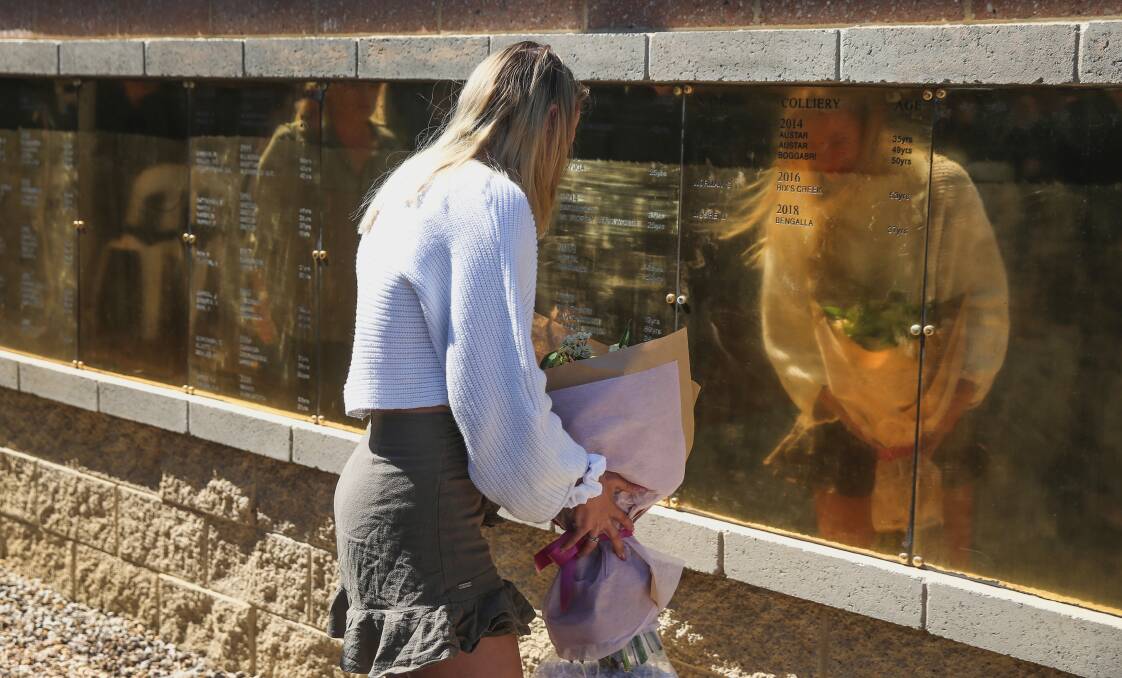 REMEMBERED: The CFMMEU Northern Mining & NSW Energy District held its 24th Annual Memorial Day Service at Aberdare on Sunday. A woman lays flowers at the Jim Comerford Memorial Wall. Picture: Marina Neil 