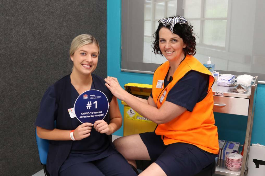 Nurse unit manager of the COVID ward, Alexandra Mexon, receives the first COVID-19 vaccine at the John Hunter Hospital vaccination hub.