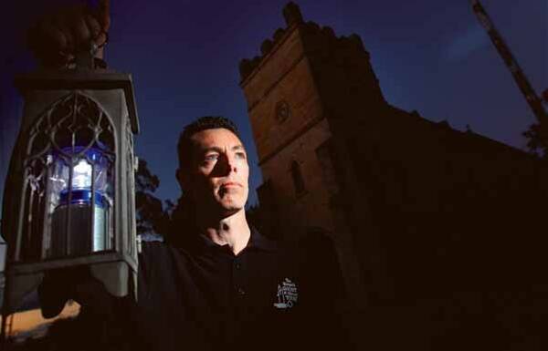 IN THE DARK: Ghost guide Troy Murphie outside Morpeth's St James' Anglican Church. - Picture by Ryan Osland