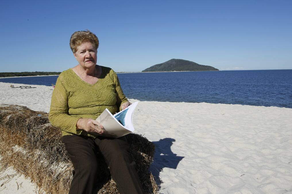 PIONEER TALES:  Author Janis Winn holds a copy of her new book about the history of Tea Gardens area at Jimmy’s Beach.  Picture: Anita Jones