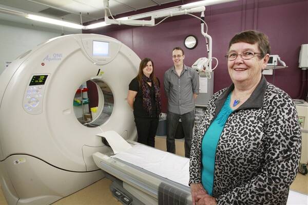 HAPPY: HMRI life governor Jennie Thomas, right, and researchers Amelia Tomkins, left, and Andrew Bivard, with a CT scanner at John Hunter hospital. –  Picture by Peter Stoop