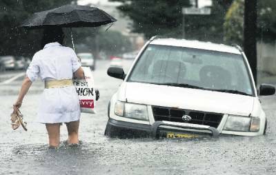 WADING: Union Street yesterday. - Pictures by Natalie Grono, Simone De Peak, Darren Pateman and Dean Osland ,0,10,14:  SLOW GOING: A car leaves Westfield Kotara car park yesterday.  OPPORTUNITY: A youth practises his surfing skills in National Park.
