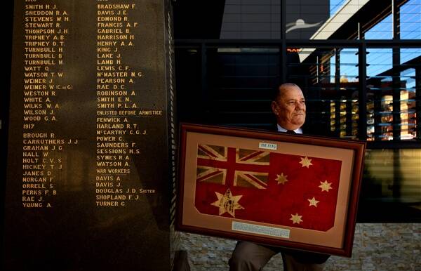 BLOOD RED: Doug Wallace displays the flag that flew at Gallipoli. –  Picture by Simone De Peak