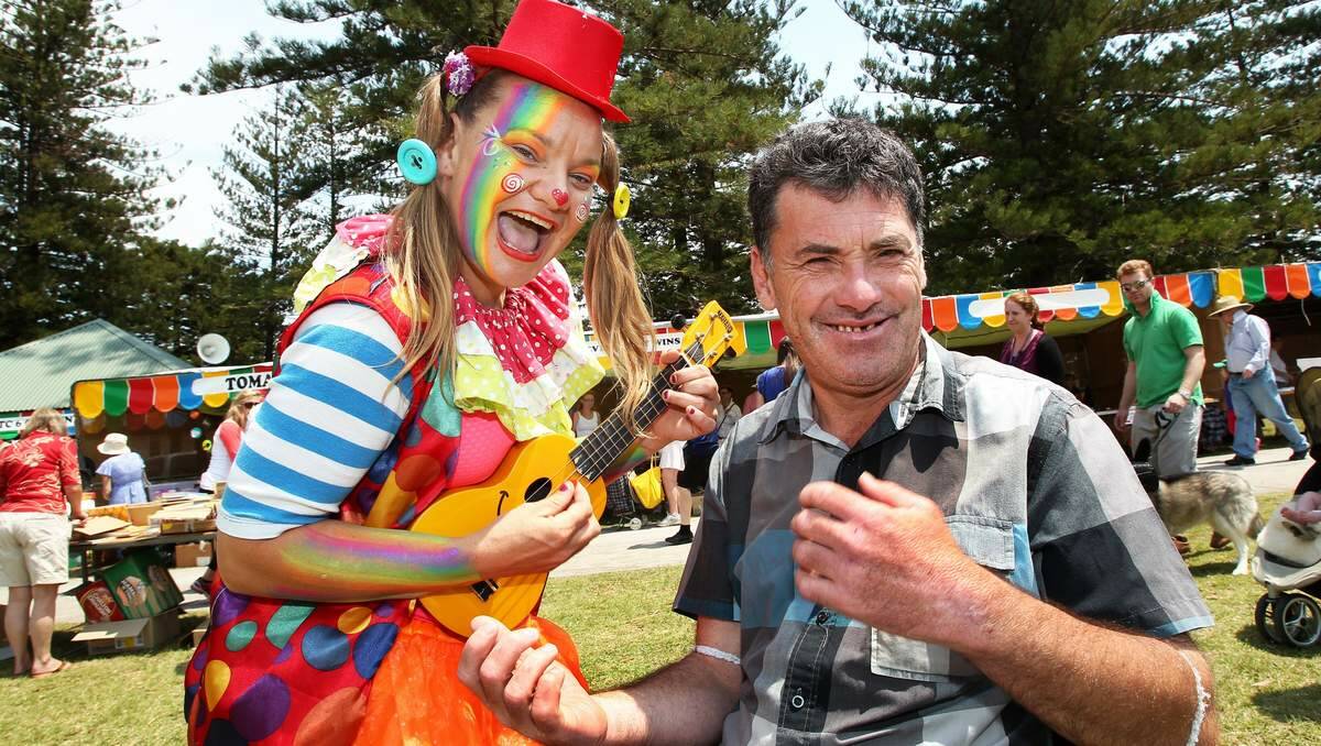GOOD CHEER: Ruby the clown plays a tune to Paul Cooper from Warabrook at the fete. Picture: Phil Hearne