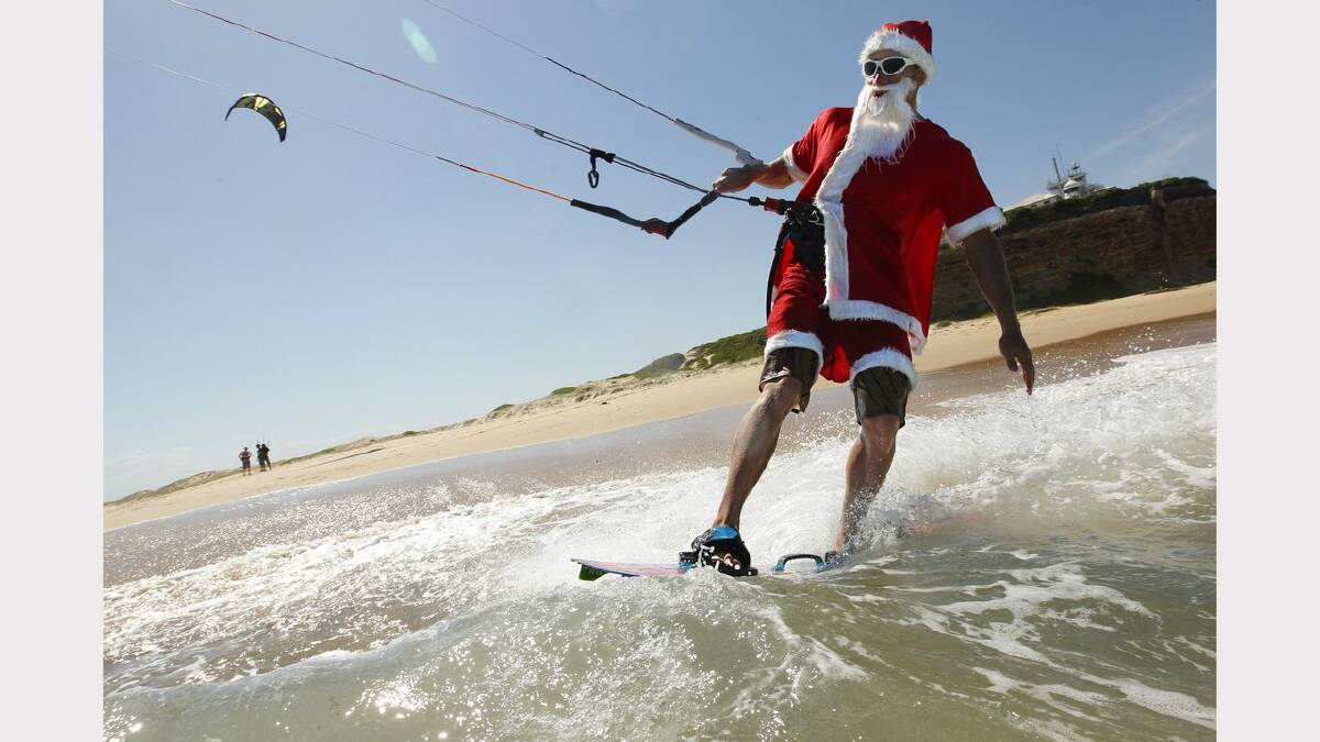 Kite-surfing Santas at Nobbys Beach, Newcastle. Franz Riembauer in action. Picture Jonathan Carroll. 