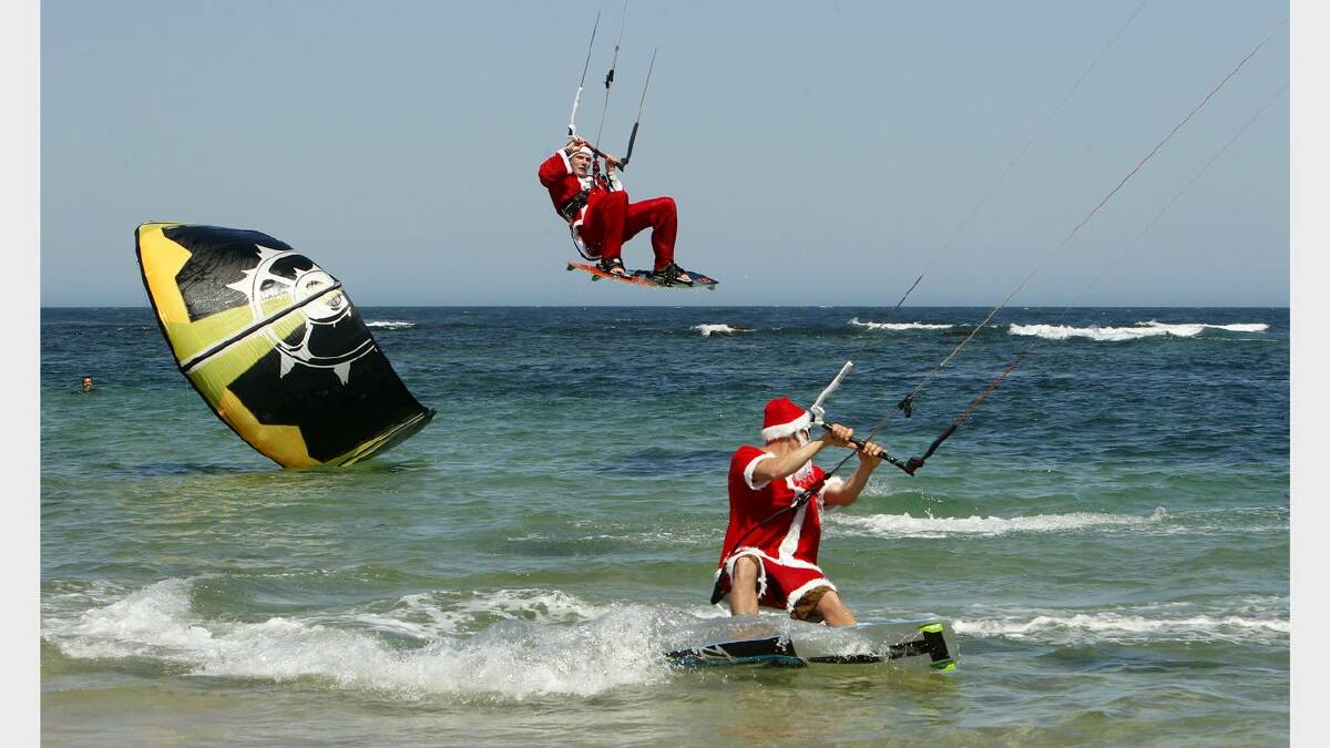 Kite-surfing Santas at Nobbys Beach, Newcastle. James Vandervoort, top, and Franz Riembauer, bottom. Picture Jonathan Carroll. 