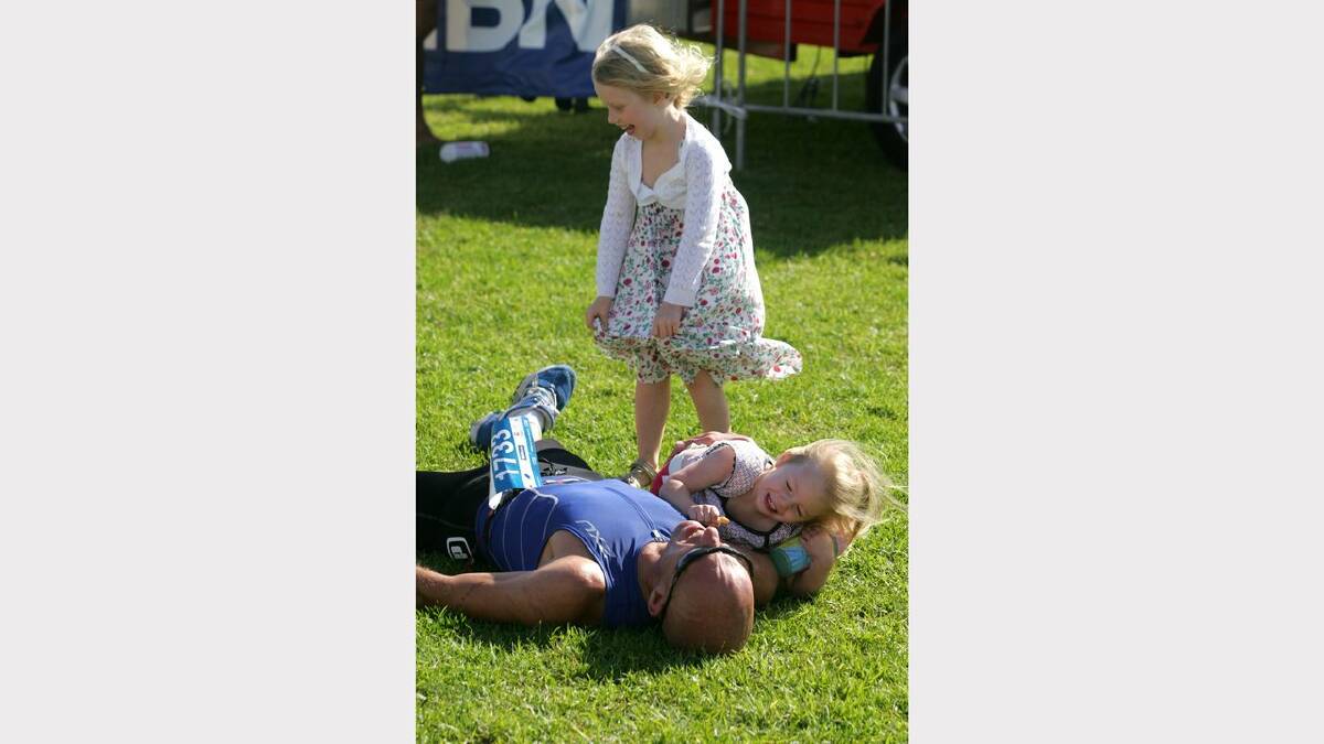 ENERGY: Action from the Sparke Helmore NBN Triathlon in Newcastle on Sunday. Dave Bonsor of Merwether Heights with his daughters Stella, 4, and Sophie, 1, after finishing the Olympic Distance Triathlon race. Camp Shortland, Newcastle. Picture Max Mason Hubers.
