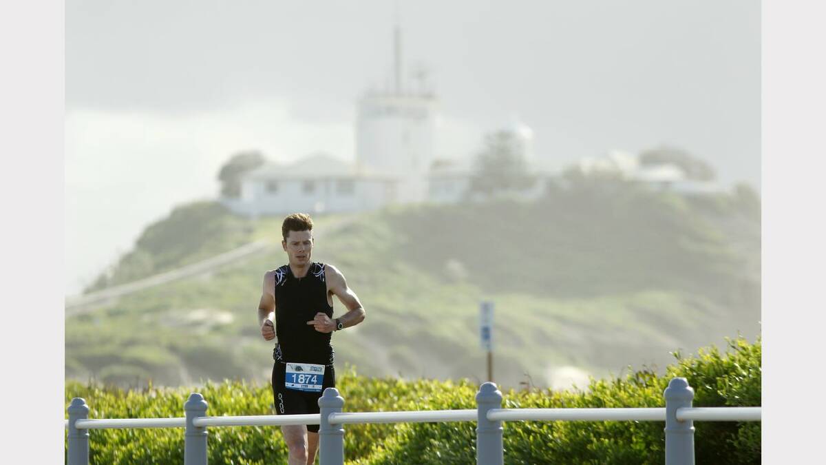ENERGY: Action from the Sparke Helmore NBN Triathlon in Newcastle on Sunday. Stephen Ryan running on Nobbys breakwall during the Olympic Distance Triathlon race. Picture Max Mason Hubers.