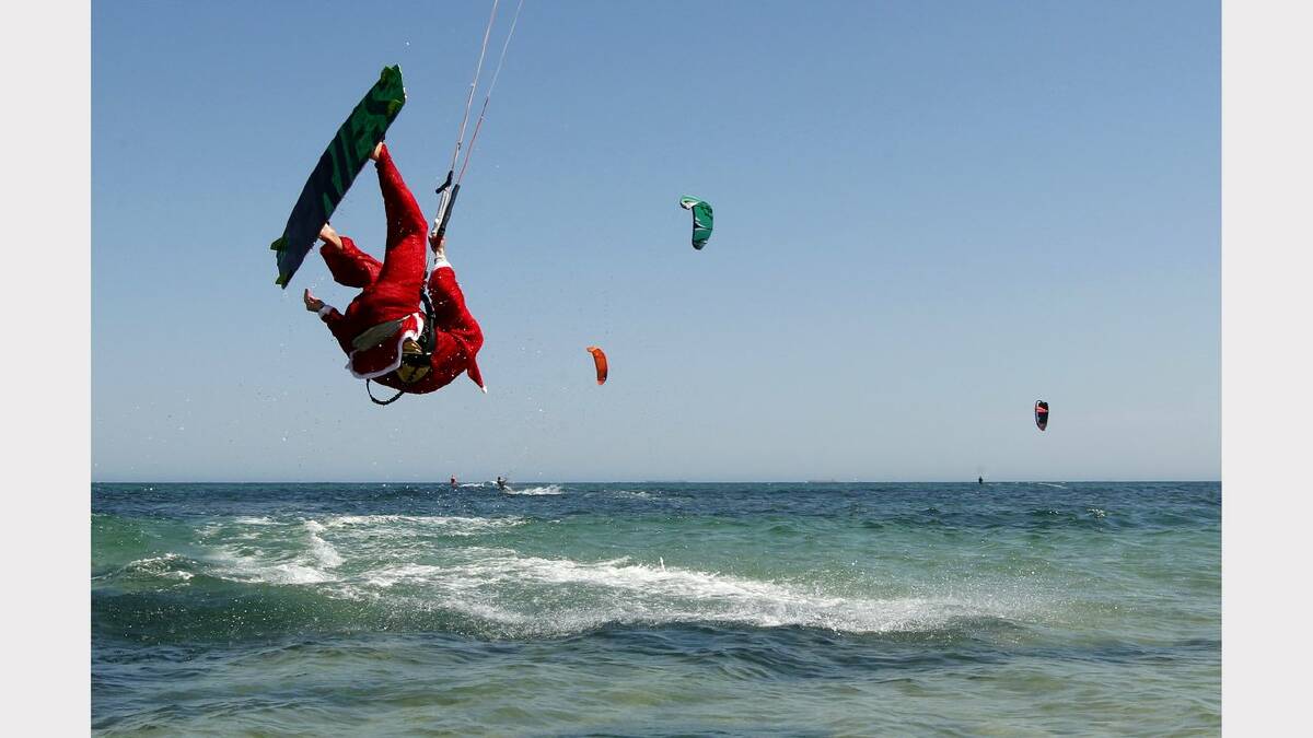 Kite-surfing Santas at Nobbys Beach, Newcastle. James Vandervoort  in action. Picture Jonathan Carroll. 