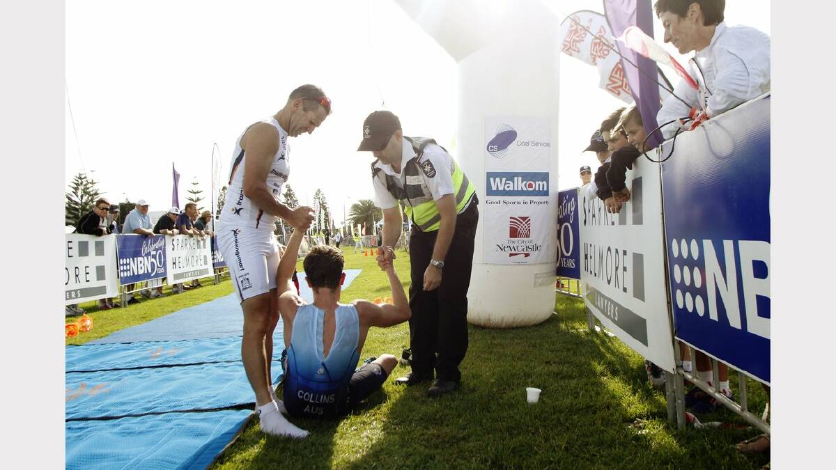 ENERGY: Action from the Sparke Helmore NBN Triathlon in Newcastle on Sunday.  Olympic Distance Triathlon runner up Tim Lang (L) joining a paramedic in lifting Elliott Collins who was indisposed for several minutes after crossing the line in third place. Picture Max Mason Hubers.