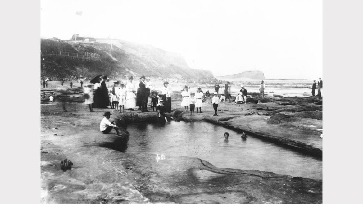 ARCHIVAL REVIVAL 1900s: Photographs from the Newcastle Herald's files.  People clustered around a natural rock pool where the Newcastle Ocean baths now exists, about 1900.