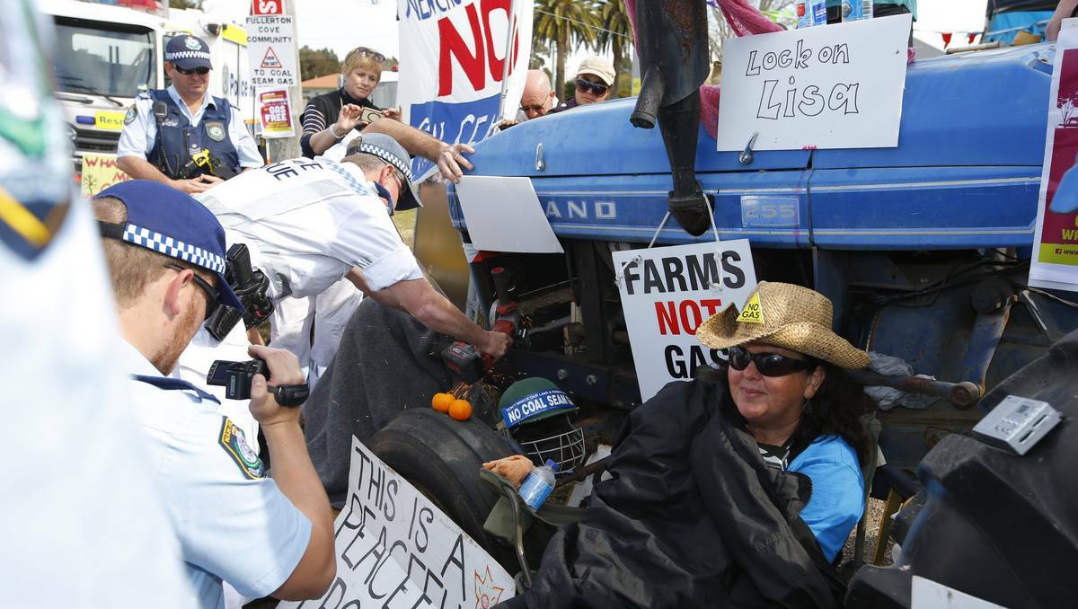 SEVERING TIES: Police Rescue cut protester Julie Wood from a tractor.  Pictures: Peter Stoop