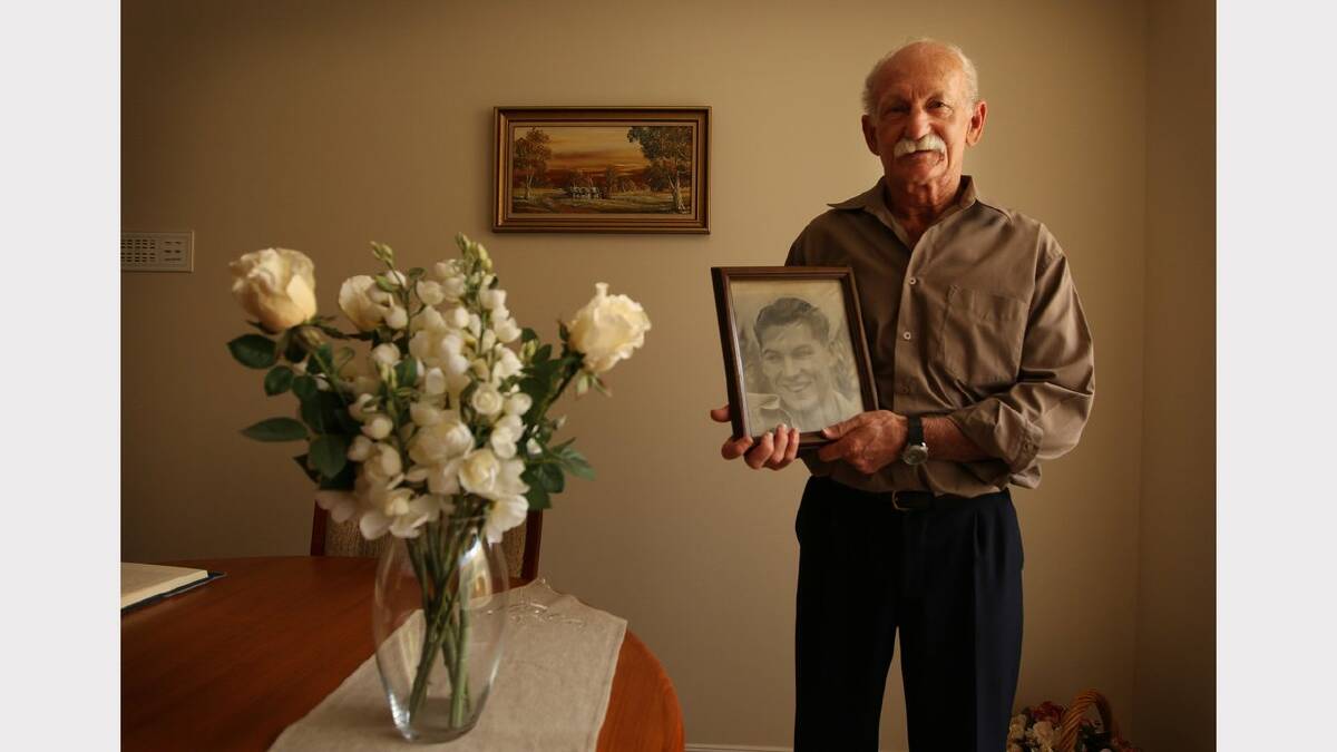 Ken Iredale, at home in Fletcher, holds a photo of his late father Kenneth John Iredale who died when the ship Iron Knight  was sunk by torpedo in 1943. Picture Ryan Osland 