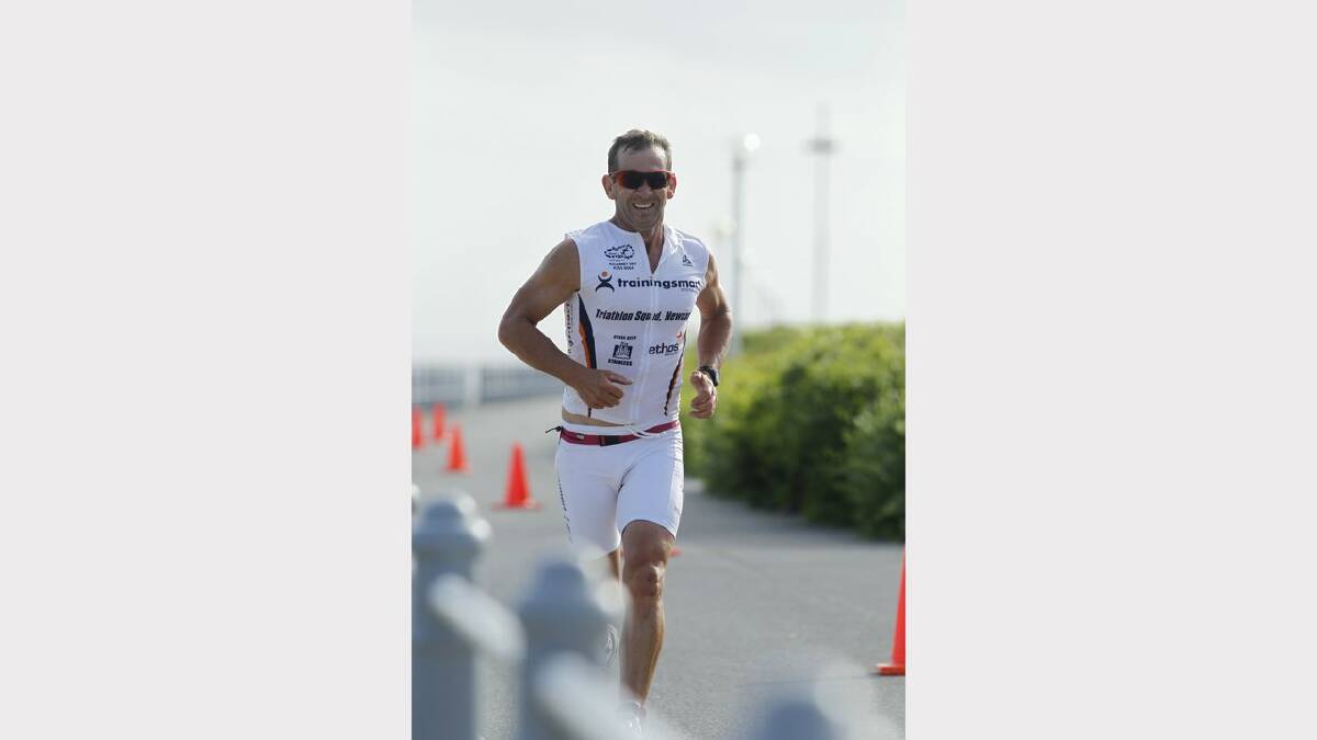 ENERGY: Action from the Sparke Helmore NBN Triathlon in Newcastle on Sunday. runner-up in the Olympic Distance Triathlon race, Tim Lang, on Nobbys breakwall. Picture Max Mason Hubers.