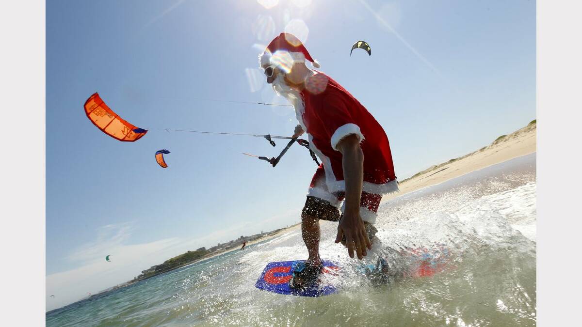 Kite-surfing Santas at Nobbys Beach, Newcastle. Franz Riembauer in action. Picture Jonathan Carroll. 