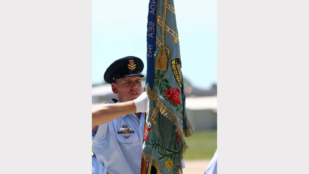 Williamtown RAAF base hosts 70th anniversary of 41, 42 and 44 wings. Flight Lieutenant Andrew Boeree carries the wing's colours. Picture Brock Perks