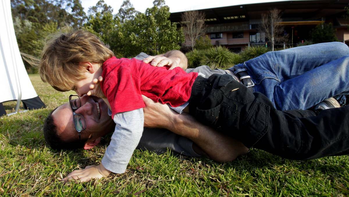 PLAYTIME: Zeke Marosszeky, of Cooks Hill, wrestles with his son Sam on the oval at Callaghan campus.  Picture: Max Mason-Hubers