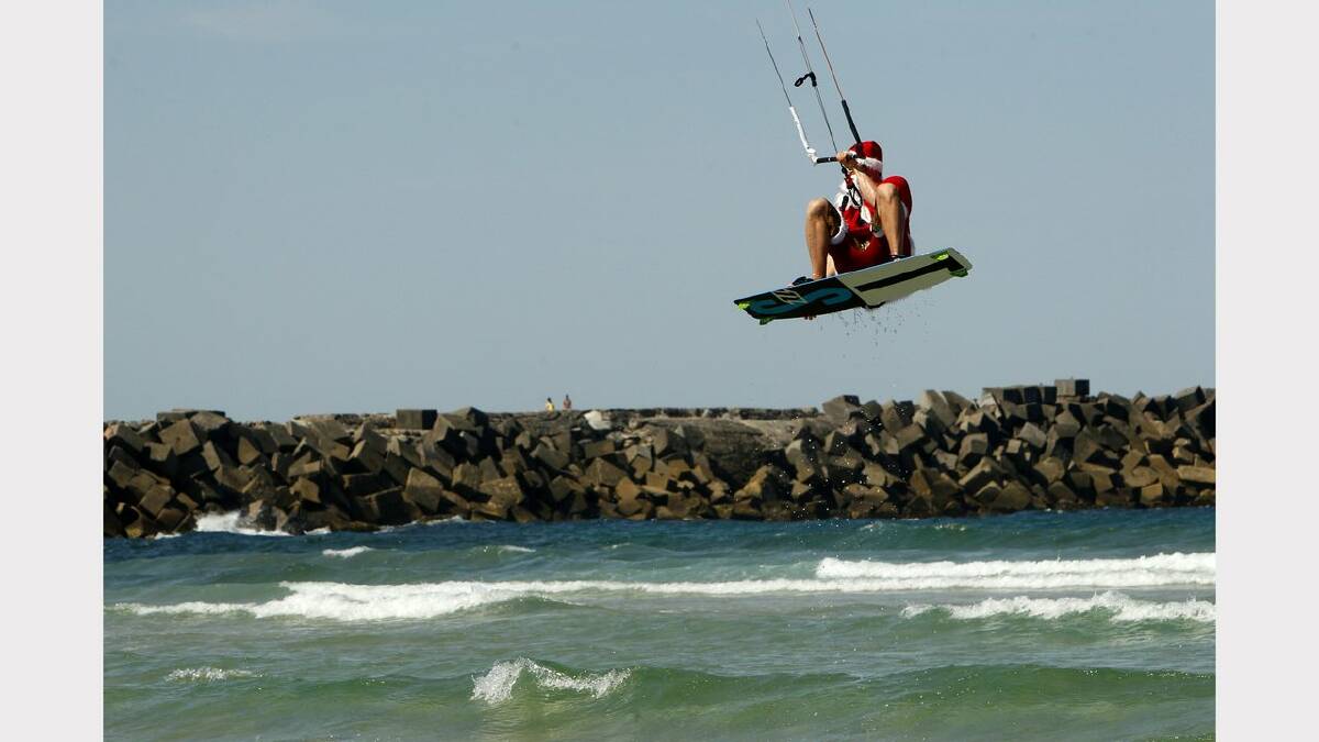 Kite-surfing Santas at Nobbys Beach, Newcastle.   Franz Riembauer in action. Picture Jonathan Carroll. 