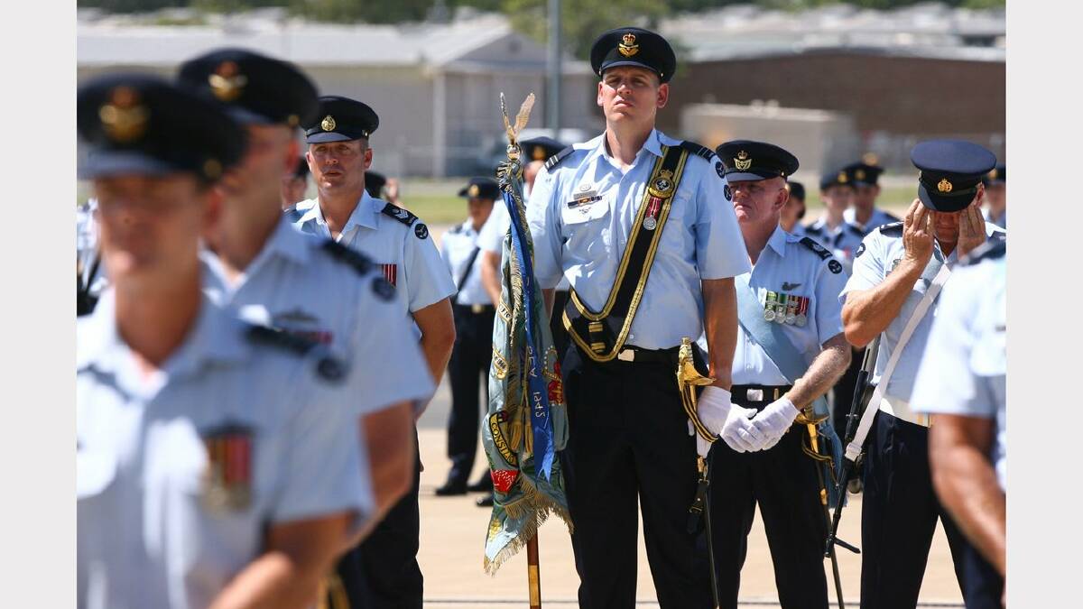 Williamtown RAAF base hosts 70th anniversary of 41, 42 and 44 wings. Flight Lieutenant Andrew Boeree, centre, carries the wing's colours. Picture Brock Perks