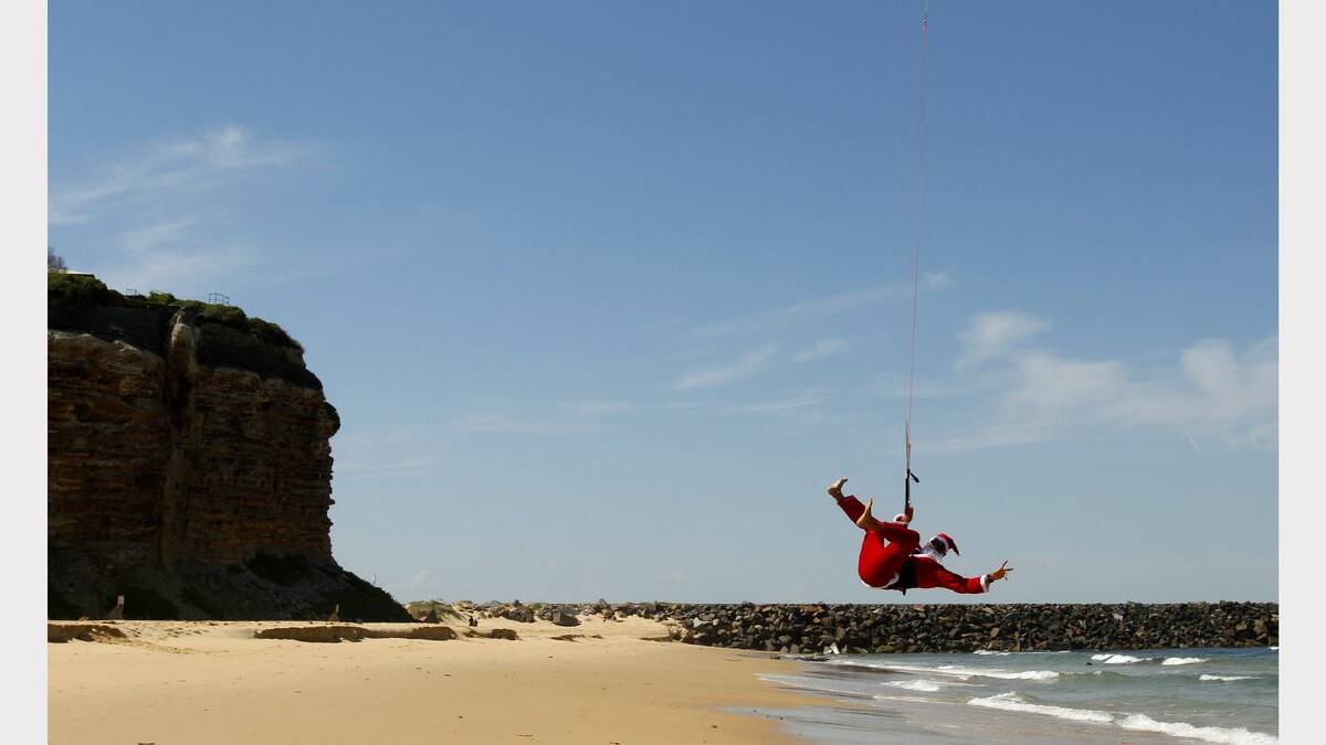 Kite-surfing Santas at Nobbys Beach, Newcastle. Craig Shales  in action. Picture Jonathan Carroll. 