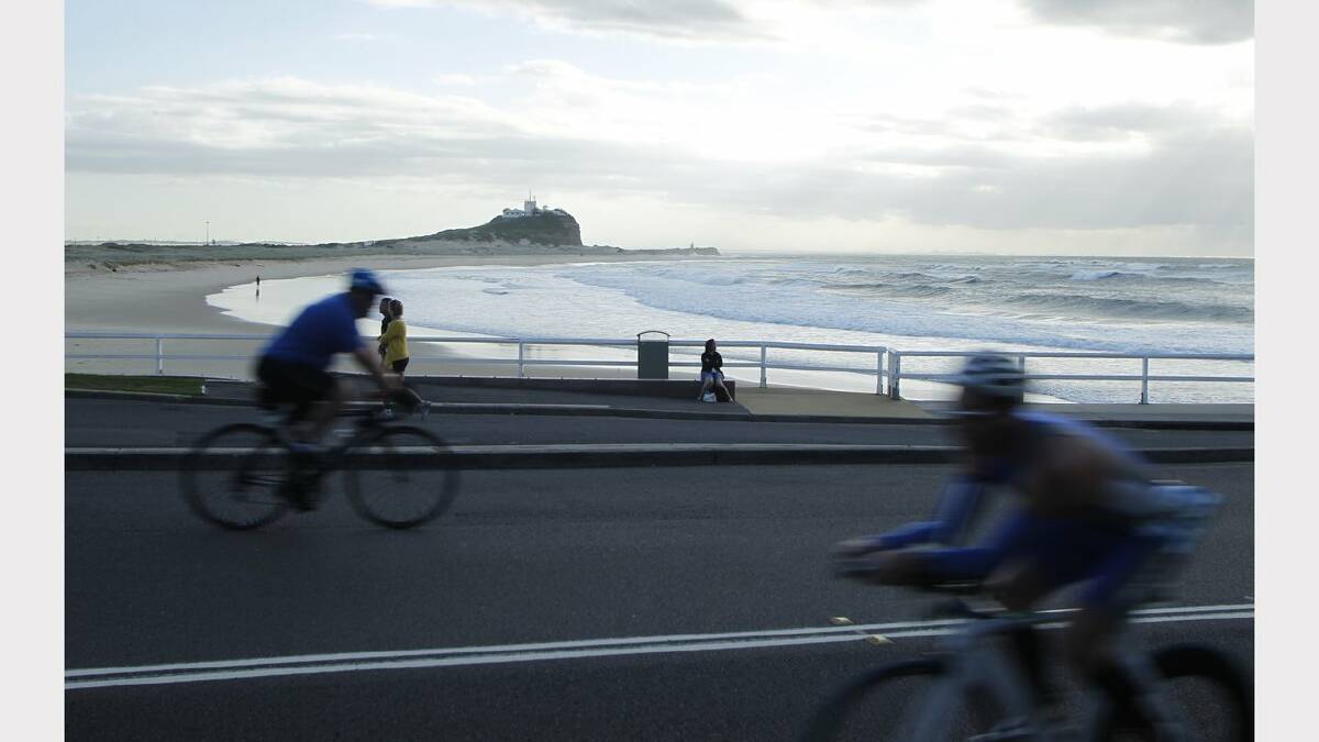 ENERGY: Action from the Sparke Helmore NBN Triathlon in Newcastle on Sunday. Olympic Distance Triathlon competitors with Nobbys Lighthouse in the background during the cycling leg of the race.  Picture Max Mason Hubers.