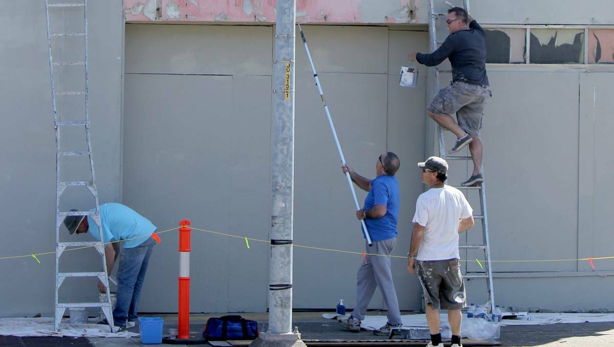 INITIATIVE: Volunteers paint a building in Newcastle West.  Picture: Chad Watson