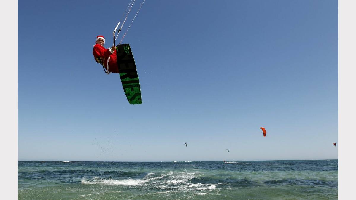 Kite-surfing Santas at Nobbys Beach, Newcastle. James Vandervoort  in action. Picture Jonathan Carroll. 