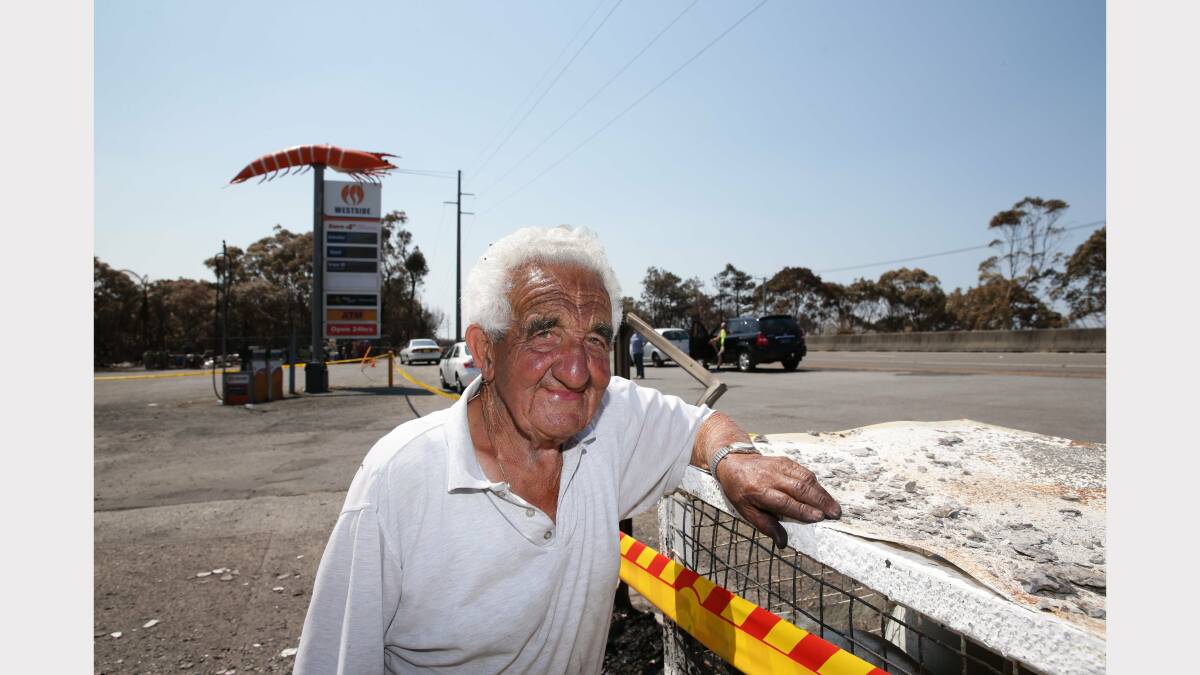 Ken Silverside with the ashes of the service station that was the Big Prawn on the Pacific Highway south of Swansea. Picture by Ryan Osland