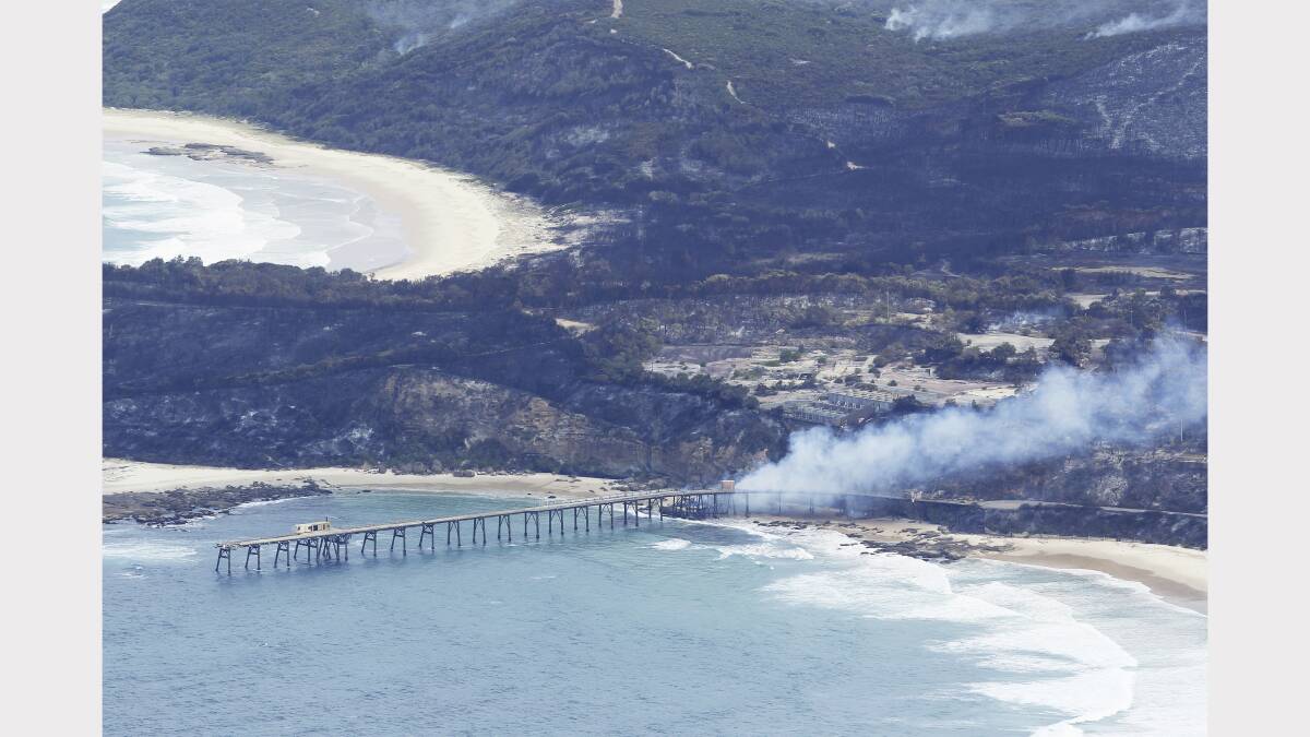 Scenes from the fires at Catherine Hill Bay and Chain Valley Bay on Friday. Photo by James Brickwood