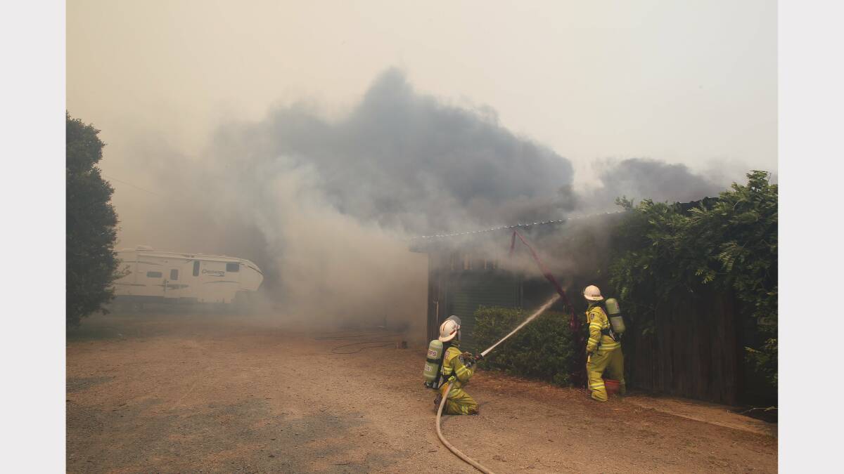 Firefighters battle fire Michelle's dog grooming shed beside a home on Cabbage Tree Road. Photo by PHIL HEARNE 